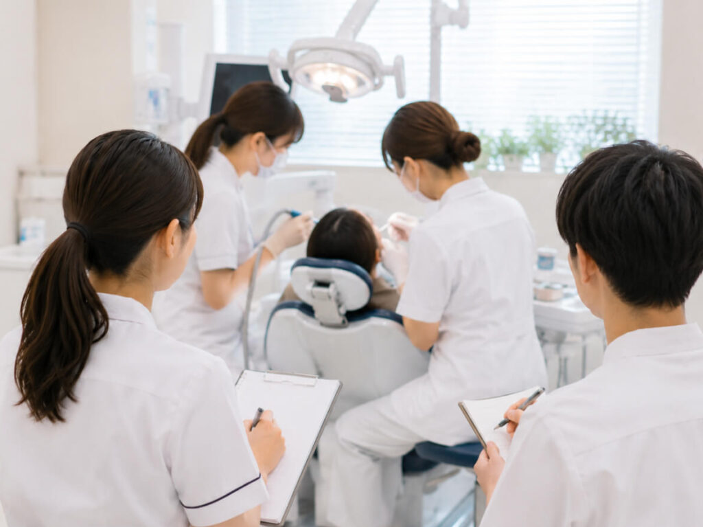 診療中の連携を見学しながらメモを取る新人スタッフの様子