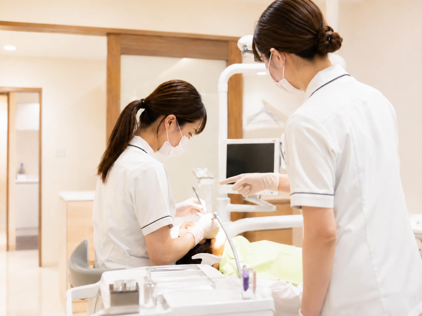 処置中の若手スタッフへ先輩が指導している様子