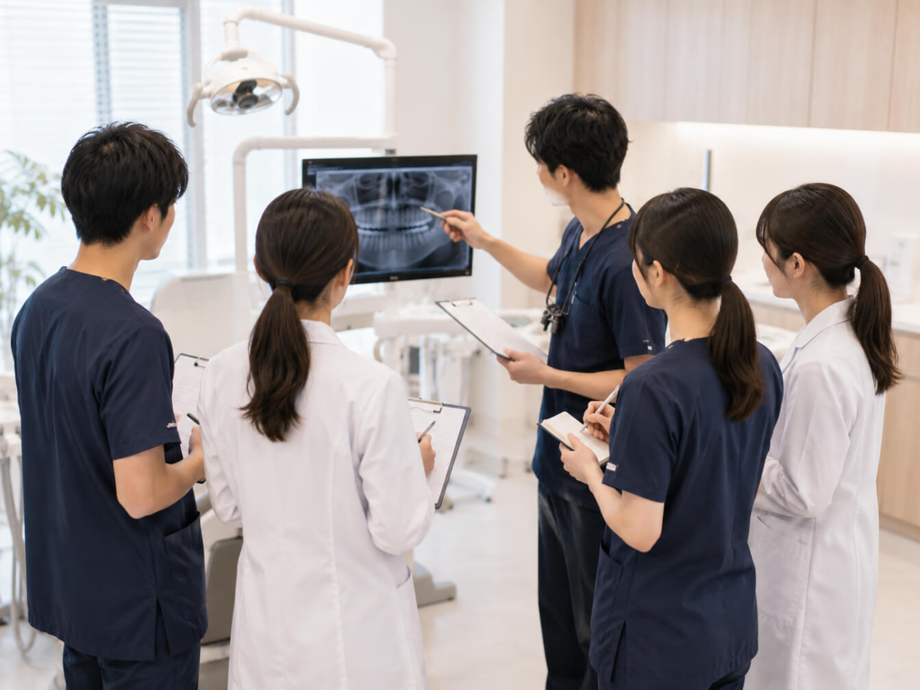 専門医が若手勤務医へレントゲン画像を使って説明している様子