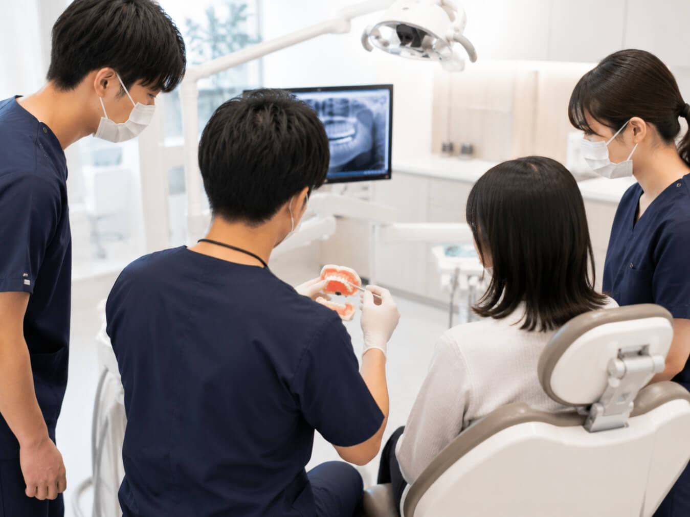 専門医が若手勤務医へ模型を使って指導している様子